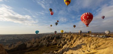 Kapadokya 'da uçan balonlar, gün doğumunda Greme' de. Kapadokya tüm dünyada sıcak hava balonlarıyla uçmak için en iyi yerlerden biri olarak bilinir.. 