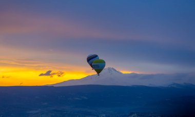 Kayseri 'deki volkanik erciyeler dağı güneş doğarken etrafında uçan kapadokya balonları.