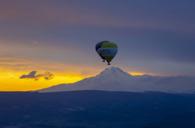 Kayseri 'deki volkanik erciyeler dağı güneş doğarken etrafında uçan kapadokya balonları.