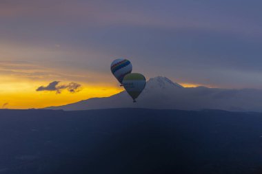 Kayseri 'deki volkanik erciyeler dağı güneş doğarken etrafında uçan kapadokya balonları.