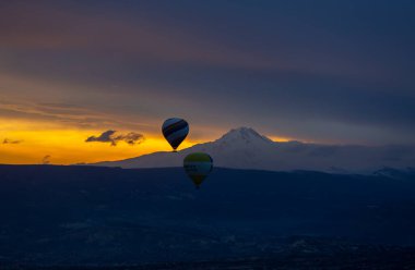 Kayseri 'deki volkanik erciyeler dağı güneş doğarken etrafında uçan kapadokya balonları.