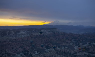 Kayseri 'deki volkanik erciyeler dağı güneş doğarken etrafında uçan kapadokya balonları.