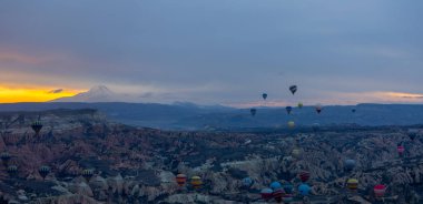Kayseri 'deki volkanik erciyeler dağı güneş doğarken etrafında uçan kapadokya balonları.