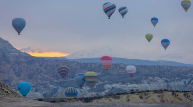 Kayseri 'deki volkanik erciyeler dağı güneş doğarken etrafında uçan kapadokya balonları.