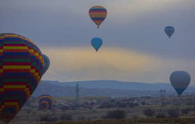Kayseri 'deki volkanik erciyeler dağı güneş doğarken etrafında uçan kapadokya balonları.