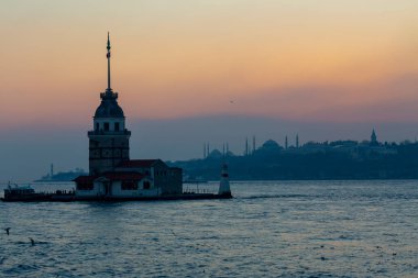 İstanbul, Türkiye 'nin sembolü Leander' s Tower olarak da bilinen ünlü Maiden 's Tower (Kiz Kulesi) ile Boğaz' ın üzerinde kızgın bir günbatımı. Duvar kağıdı veya rehber kitap için sahne yolculuğu arkaplanı