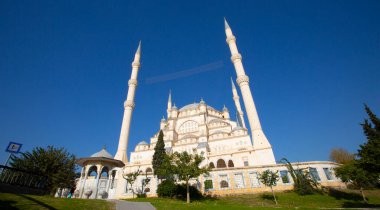 Sabancı Merkez Camii, Adana'da Eski Saat Kulesi ve Taş Köprü. Seyhan Nehri önünde cami minareleri ile Adana Belediyesi.