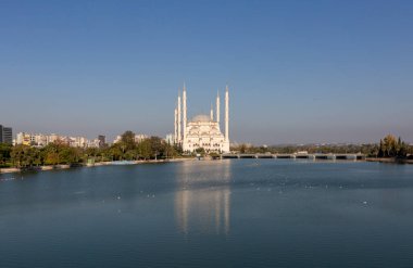 Sabancı Merkez Camii, Adana'da Eski Saat Kulesi ve Taş Köprü. Seyhan Nehri önünde cami minareleri ile Adana Belediyesi.
