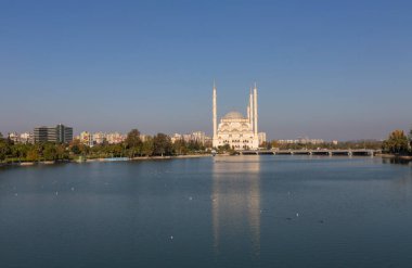 Sabancı Merkez Camii, Adana'da Eski Saat Kulesi ve Taş Köprü. Seyhan Nehri önünde cami minareleri ile Adana Belediyesi.