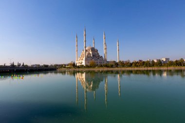 Sabancı Merkez Camii, Adana'da Eski Saat Kulesi ve Taş Köprü. Seyhan Nehri önünde cami minareleri ile Adana Belediyesi.