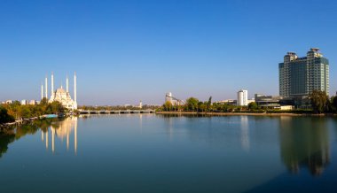 Sabancı Merkez Camii, Adana'da Eski Saat Kulesi ve Taş Köprü. Seyhan Nehri önünde cami minareleri ile Adana Belediyesi.