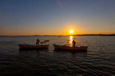 Balıkçılar göle ağ atıyorlar.