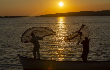 Balıkçılar göle ağ atıyorlar.