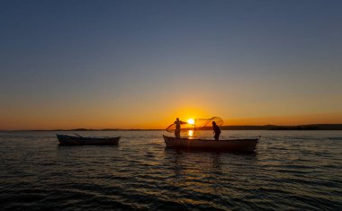 Balıkçılar göle ağ atıyorlar.
