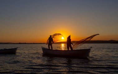 Balıkçılar göle ağ atıyorlar.
