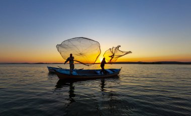 Balıkçılar göle ağ atıyorlar.