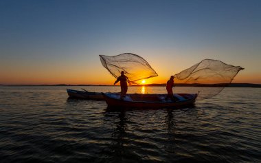 Balıkçılar göle ağ atıyorlar.