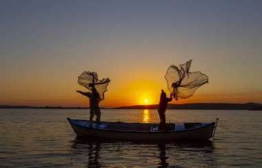Balıkçılar göle ağ atıyorlar.