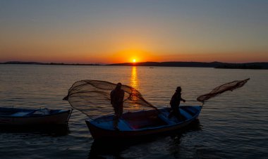 Balıkçılar göle ağ atıyorlar.