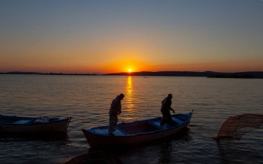 Balıkçılar göle ağ atıyorlar.