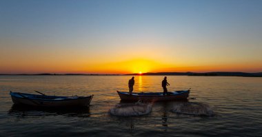 Balıkçılar göle ağ atıyorlar.