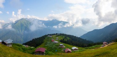 Dağlık arazide geleneksel ahşap evler. Manzara fotoğrafı Türkiye 'nin Pokut, Rize, Karadeniz / Karadeniz bölgesinde çekildi. Pokut, Rize 'nin en yüksek rakımlı tatil beldelerinden biridir..