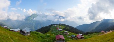 Dağlık arazide geleneksel ahşap evler. Manzara fotoğrafı Türkiye 'nin Pokut, Rize, Karadeniz / Karadeniz bölgesinde çekildi. Pokut, Rize 'nin en yüksek rakımlı tatil beldelerinden biridir..