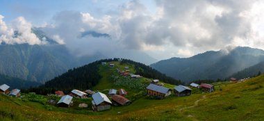 Dağlık arazide geleneksel ahşap evler. Manzara fotoğrafı Türkiye 'nin Pokut, Rize, Karadeniz / Karadeniz bölgesinde çekildi. Pokut, Rize 'nin en yüksek rakımlı tatil beldelerinden biridir..