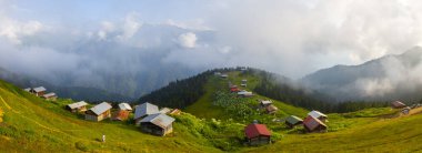 Dağlık arazide geleneksel ahşap evler. Manzara fotoğrafı Türkiye 'nin Pokut, Rize, Karadeniz / Karadeniz bölgesinde çekildi. Pokut, Rize 'nin en yüksek rakımlı tatil beldelerinden biridir..