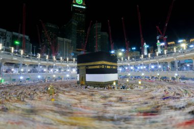 Umra ya da Hac sırasında Mekke 'deki Kutsal Kabe' de Tawaf yapan, Mescid-i Haram 'ın tepesinden bakan bir grup insan. Geceleri uzun pozlama