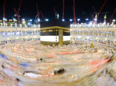 Umra ya da Hac sırasında Mekke 'deki Kutsal Kabe' de Tawaf yapan, Mescid-i Haram 'ın tepesinden bakan bir grup insan. Geceleri uzun pozlama