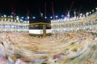 Umra ya da Hac sırasında Mekke 'deki Kutsal Kabe' de Tawaf yapan, Mescid-i Haram 'ın tepesinden bakan bir grup insan. Geceleri uzun pozlama
