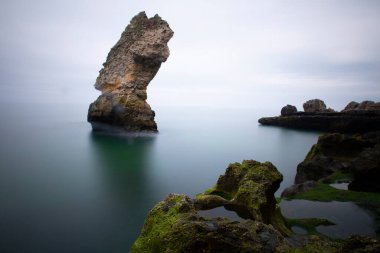 Deniz kenarındaki büyük kayalar uzun pozlama tekniğiyle açıktır.