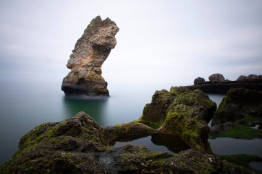 Deniz kenarındaki büyük kayalar uzun pozlama tekniğiyle açıktır.
