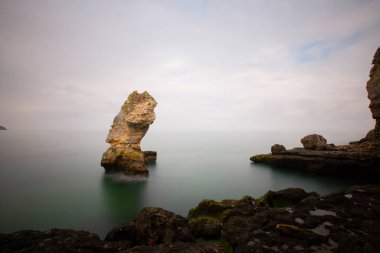 Deniz kenarındaki büyük kayalar uzun pozlama tekniğiyle açıktır.