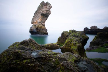 Deniz kenarındaki büyük kayalar uzun pozlama tekniğiyle açıktır.