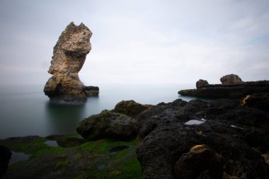 Deniz kenarındaki büyük kayalar uzun pozlama tekniğiyle açıktır.