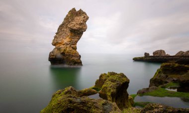 Deniz kenarındaki büyük kayalar uzun pozlama tekniğiyle açıktır.