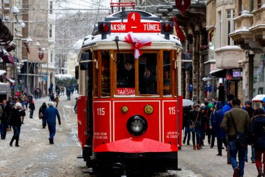 İnsanlar kar altında Istiklal Caddesi 'nde yürürken aynı zamanda tarihi kırmızı tramvay yoluna çıkıyor..