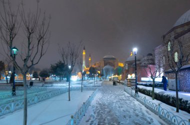 Kış günü İstanbul, Türkiye 'de kar yağan mavi cami (Sultanahmet Camii). Yerel halk Türkiye 'nin simgelerinde yürüyor.