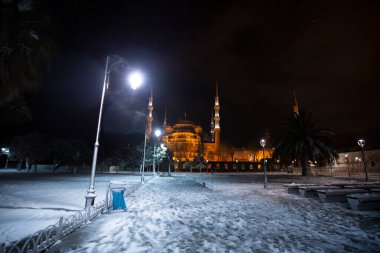 Kış günü İstanbul, Türkiye 'de kar yağan mavi cami (Sultanahmet Camii). Yerel halk Türkiye 'nin simgelerinde yürüyor.