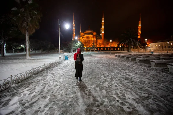 Kış günü İstanbul, Türkiye 'de kar yağan mavi cami (Sultanahmet Camii). Yerel halk Türkiye 'nin simgelerinde yürüyor.