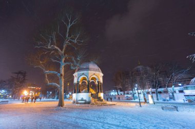 Kış günü İstanbul, Türkiye 'de kar yağan mavi cami (Sultanahmet Camii). Yerel halk Türkiye 'nin simgelerinde yürüyor.
