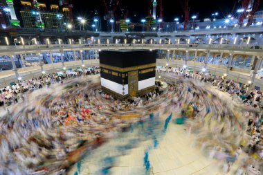Umra ya da Hac zamanlarında Mekke 'deki Kutsal Kabe' nin etrafında Tawaf yapan bir grup insan Mescid-i Haram 'ın tepesinden bakıyor. Geceleri uzun pozlama