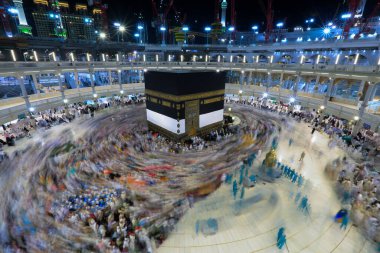 Umra ya da Hac zamanlarında Mekke 'deki Kutsal Kabe' nin etrafında Tawaf yapan bir grup insan Mescid-i Haram 'ın tepesinden bakıyor. Geceleri uzun pozlama