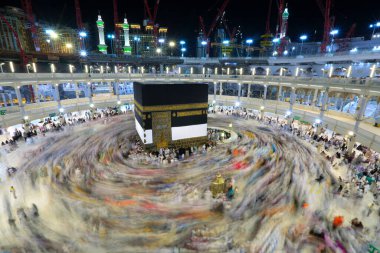 Umra ya da Hac zamanlarında Mekke 'deki Kutsal Kabe' nin etrafında Tawaf yapan bir grup insan Mescid-i Haram 'ın tepesinden bakıyor. Geceleri uzun pozlama