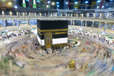Umra ya da Hac zamanlarında Mekke 'deki Kutsal Kabe' nin etrafında Tawaf yapan bir grup insan Mescid-i Haram 'ın tepesinden bakıyor. Geceleri uzun pozlama