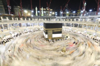 Umra ya da Hac zamanlarında Mekke 'deki Kutsal Kabe' nin etrafında Tawaf yapan bir grup insan Mescid-i Haram 'ın tepesinden bakıyor. Geceleri uzun pozlama