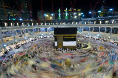 Umra ya da Hac zamanlarında Mekke 'deki Kutsal Kabe' nin etrafında Tawaf yapan bir grup insan Mescid-i Haram 'ın tepesinden bakıyor. Geceleri uzun pozlama