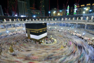 Umra ya da Hac zamanlarında Mekke 'deki Kutsal Kabe' nin etrafında Tawaf yapan bir grup insan Mescid-i Haram 'ın tepesinden bakıyor. Geceleri uzun pozlama